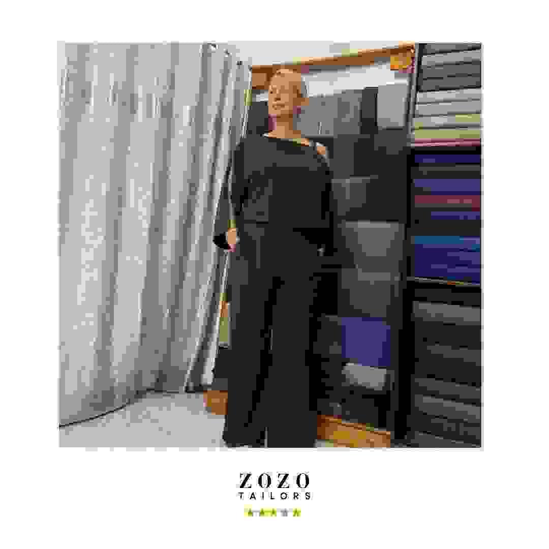 Person wearing a dark green tailored silk set (leisure-wear, top and resort style pant) Person wearing a dark green tailored silk set (leisure-wear, top and resort style pant)