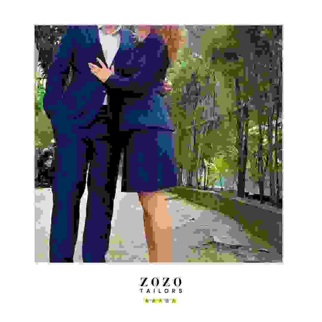 Couple wearing matching navy tailored suits (his and hers) Couple wearing matching navy tailored suits (his and hers)
