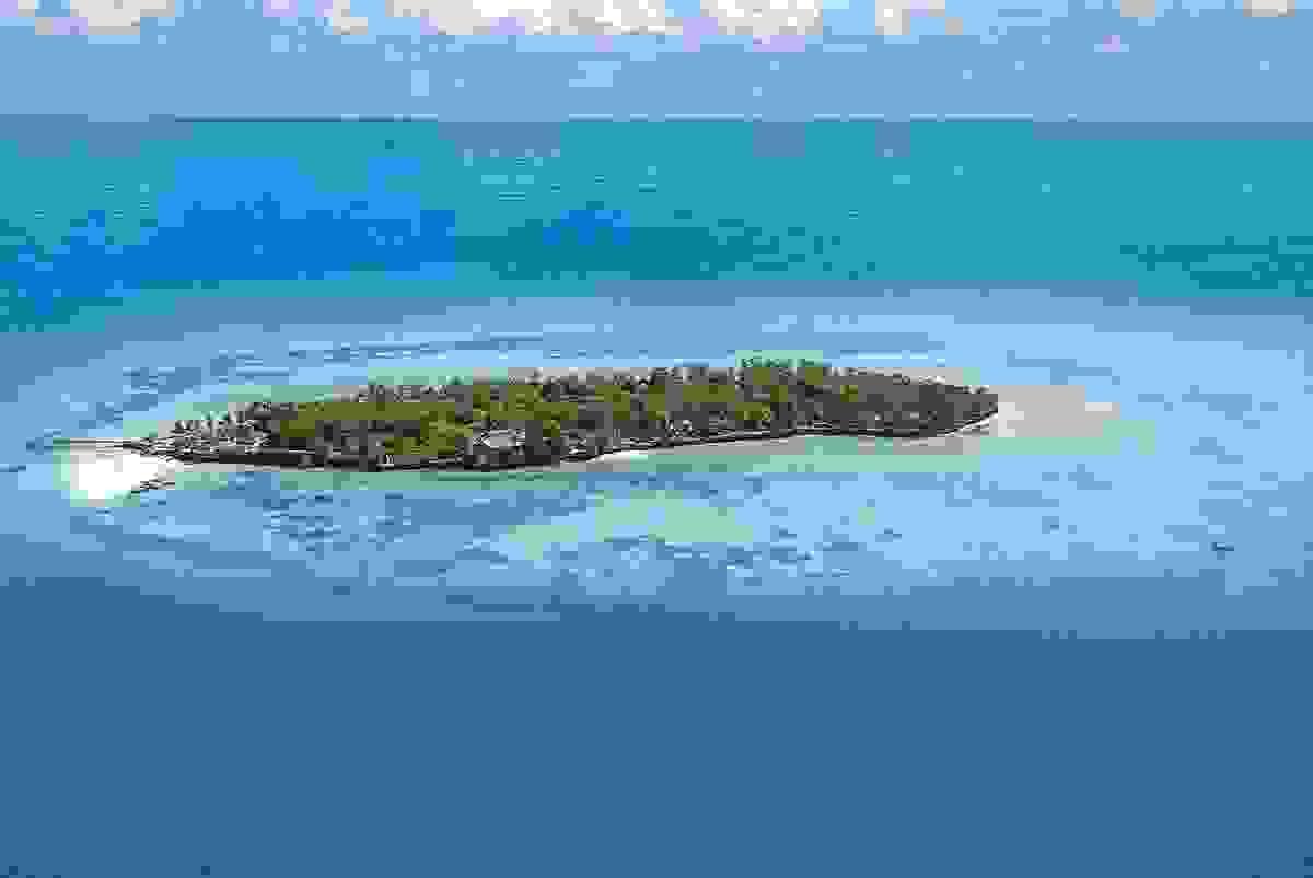 A small portion of island with few buildings on it's coast A small portion of island with few buildings on it's coast