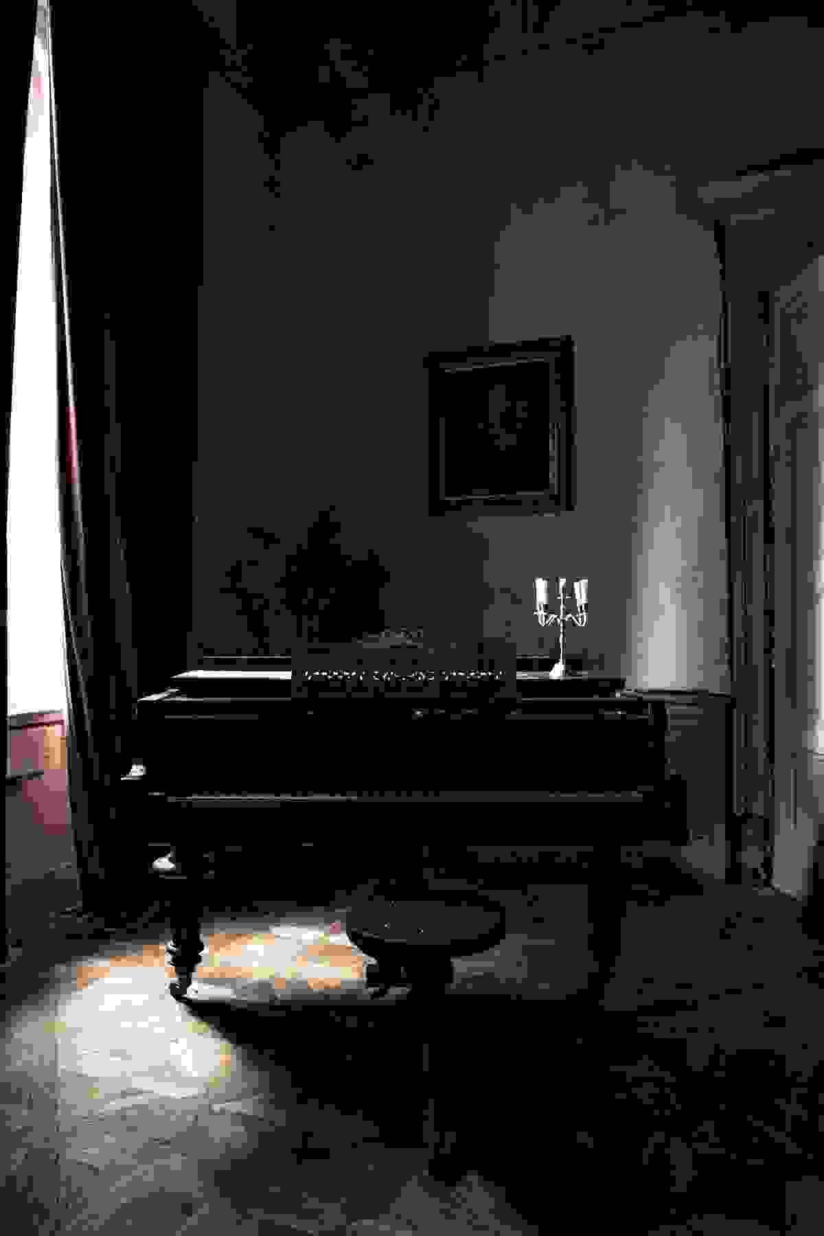 Intérieur ancien en clair-obscur avec piano et tableau Intérieur ancien en clair-obscur avec piano et tableau