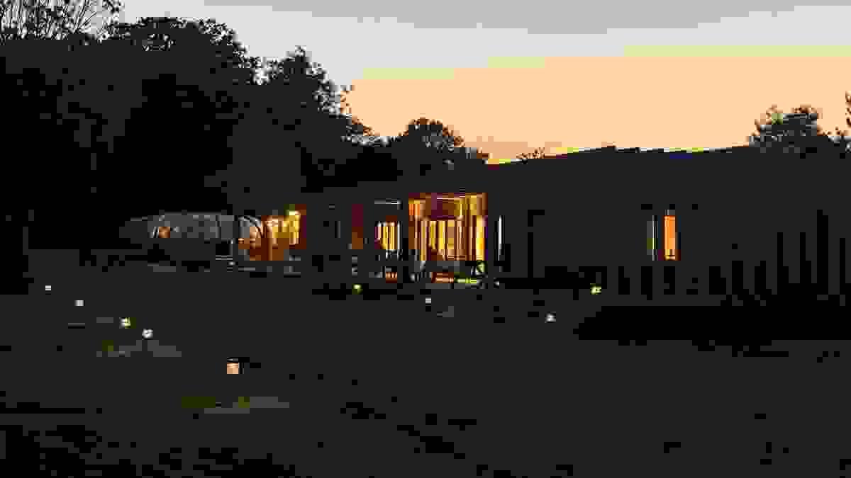 View of the Sunfolk decking and pavilion at night under warm lighting View of the Sunfolk decking and pavilion at night under warm lighting