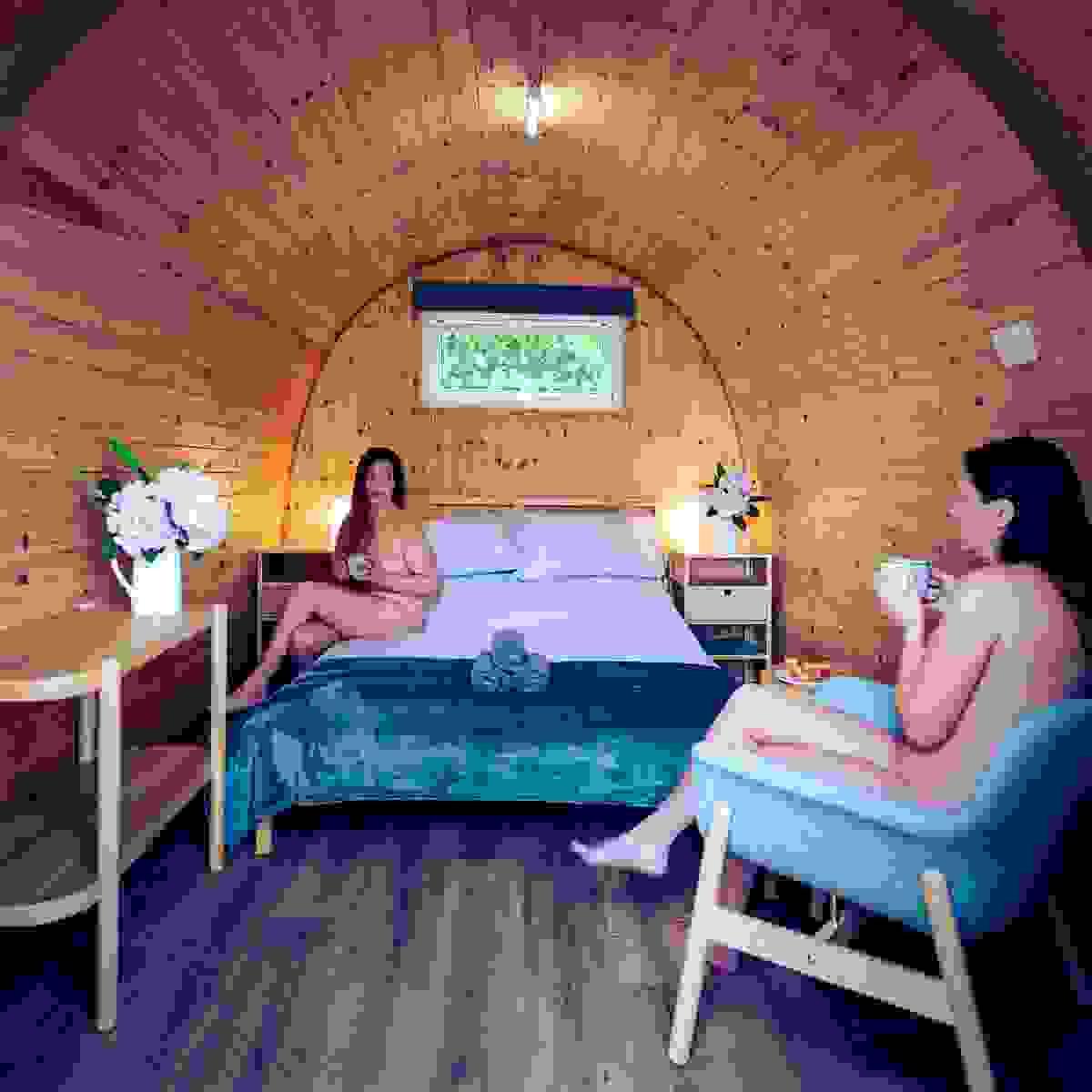 A couple enjoying a cup of tea in their glamping pod A couple enjoying a cup of tea in their glamping pod