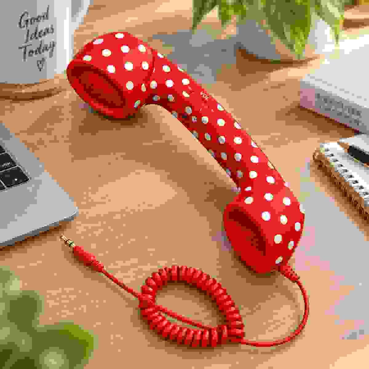 Red and white polka dot 3.5mm retro phone handset on a wooden desk lifestyle scene Red and white polka dot 3.5mm retro phone handset on a wooden desk lifestyle scene