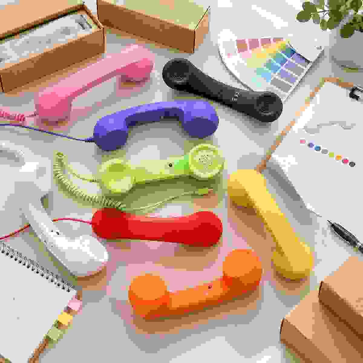 Colorful retro phone handset samples in multiple colors displayed with packaging boxes, color swatches and product planning materials for NEW POWER TECH OEM/ODM wholesale projects. Colorful retro phone handset samples in multiple colors displayed with packaging boxes, color swatches and product planning materials for NEW POWER TECH OEM/ODM wholesale projects.