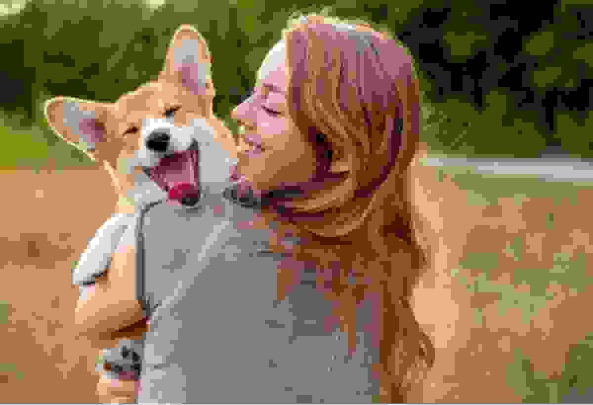 Woman hugging dog and smiling