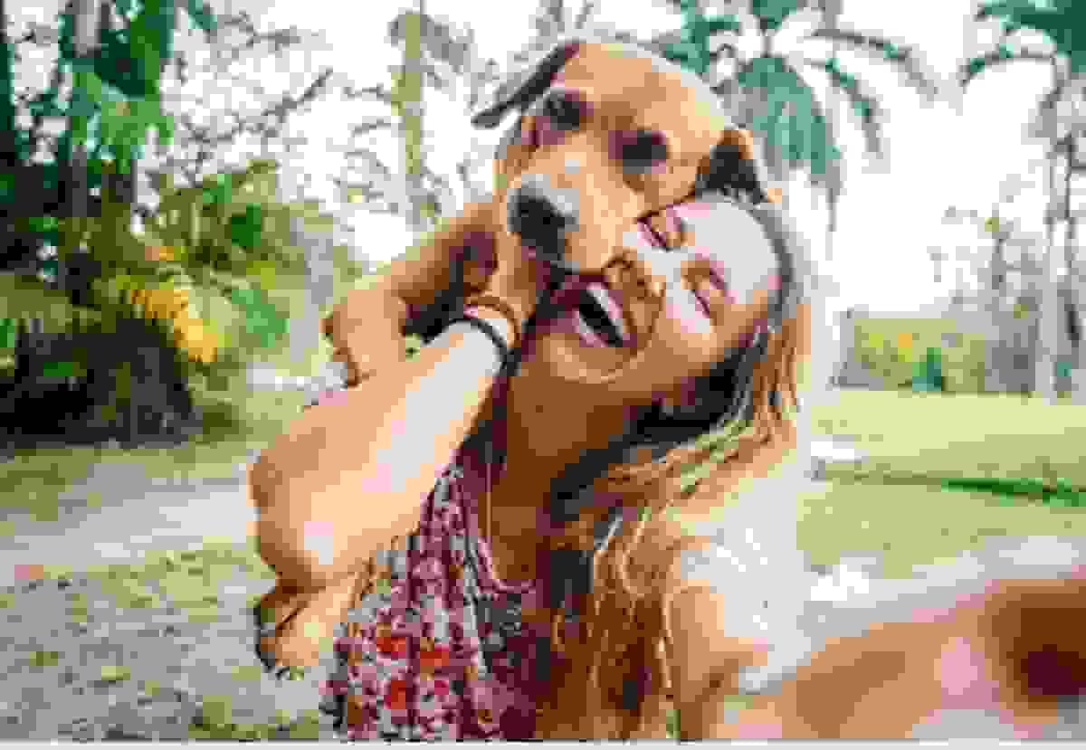 Woman hugging dog and smiling