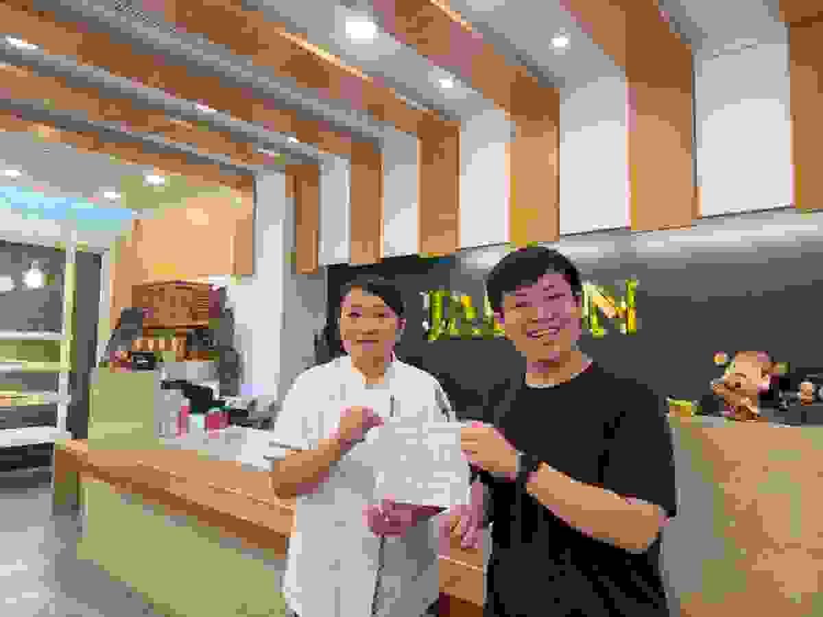 「暖暖堡」團隊成員陳柏翰(右)向店長蔡雅淇(左)遞交捐款證明