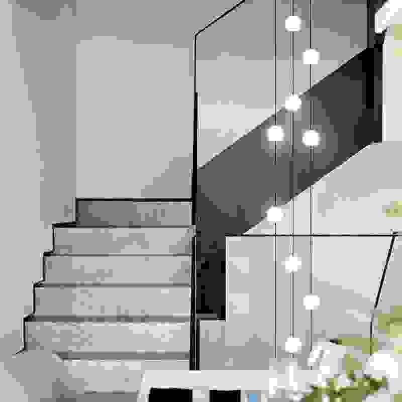 Minimalist long metal tube pendant light for narrow stairwell, ideal for modern vertical spaces and high ceilings.