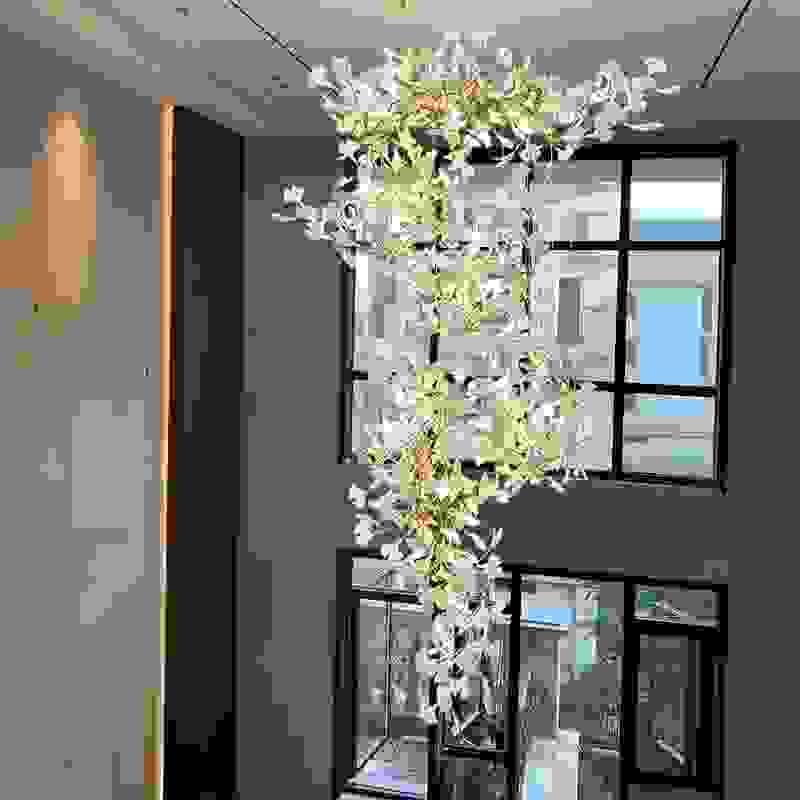 Ginkgo leaf chandelier with ceramic finish for elegant stairwell lighting.