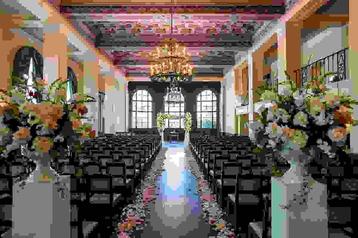 Wedding ceremony with floral pedastals and petals down the aisle
