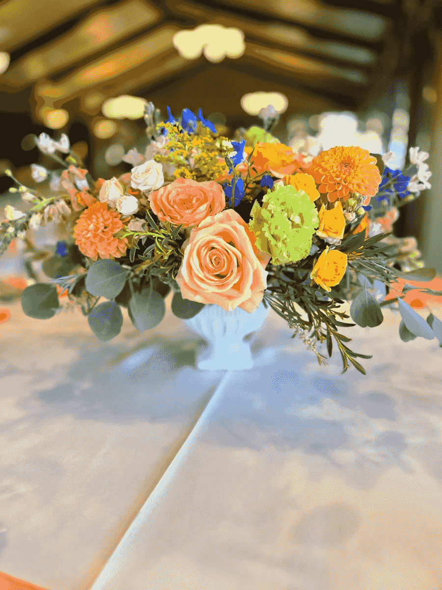 Colorful low floral centerpiece with bright orange and green