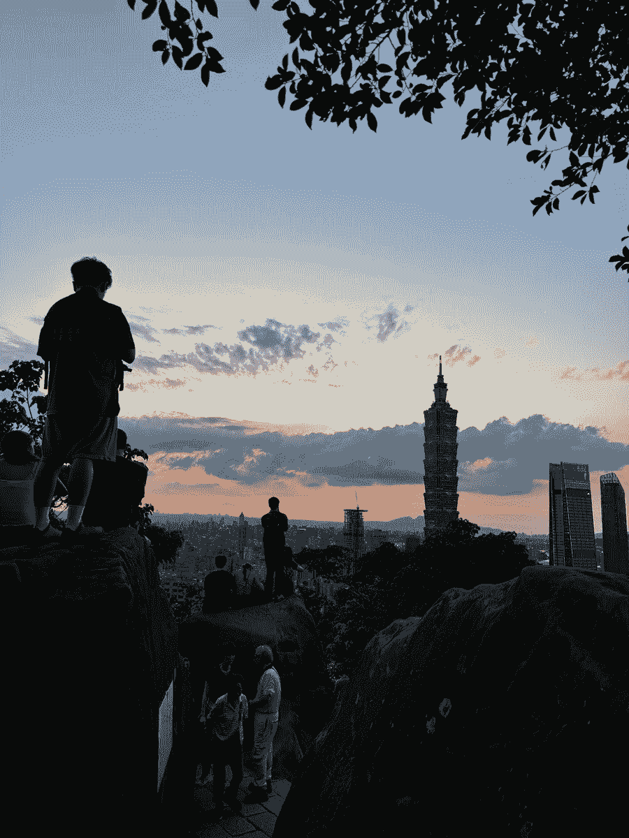The sunset view of the Taipei 101 with a crowd at the top of the Elephant Mountain