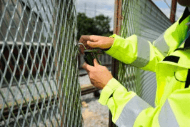Security guard performing Open and Lock Up Service using padlock on gate gensecwa.com.au