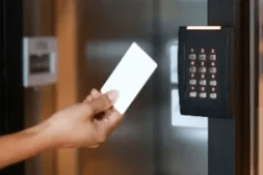 Hand holding HID iClass smart card to HID Reader on glass door