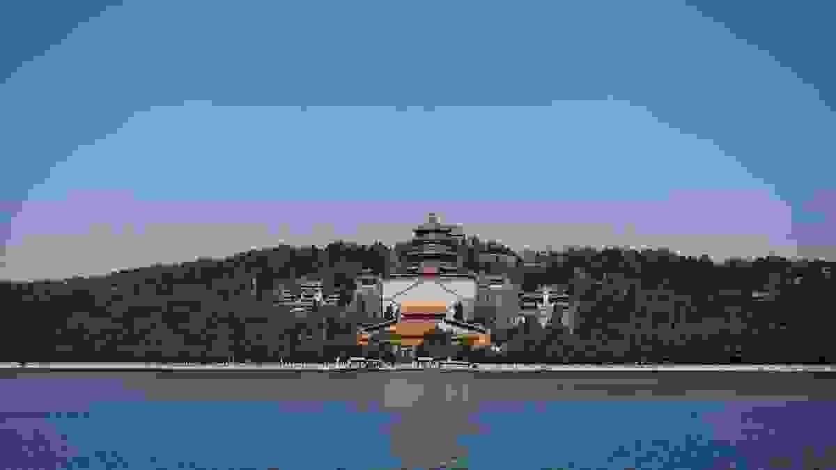The Summer Palace's ornate pavilions and towers reflected in the calm waters of Kunming Lake under a bright sky The Summer Palace's ornate pavilions and towers reflected in the calm waters of Kunming Lake under a bright sky