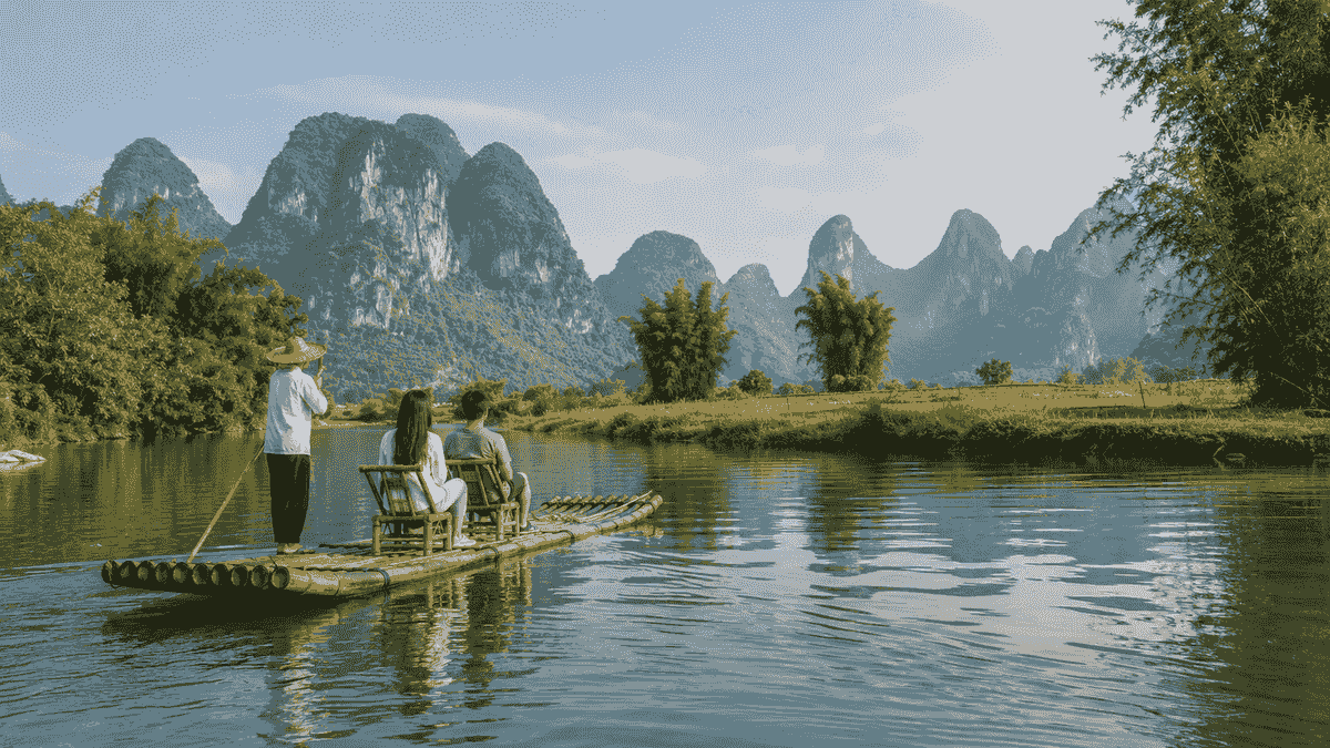 Travelers bamboo rafting on the Yulong River beneath Yangshuo karst mountains Travelers bamboo rafting on the Yulong River beneath Yangshuo karst mountains