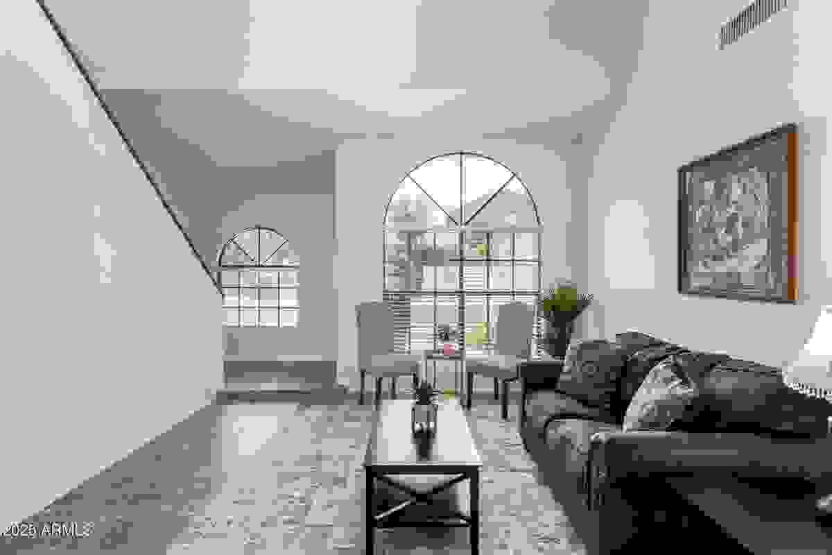 Alternate angle of front living room with vaulted ceilings and natural light in 4-bedroom Gilbert home for sale.