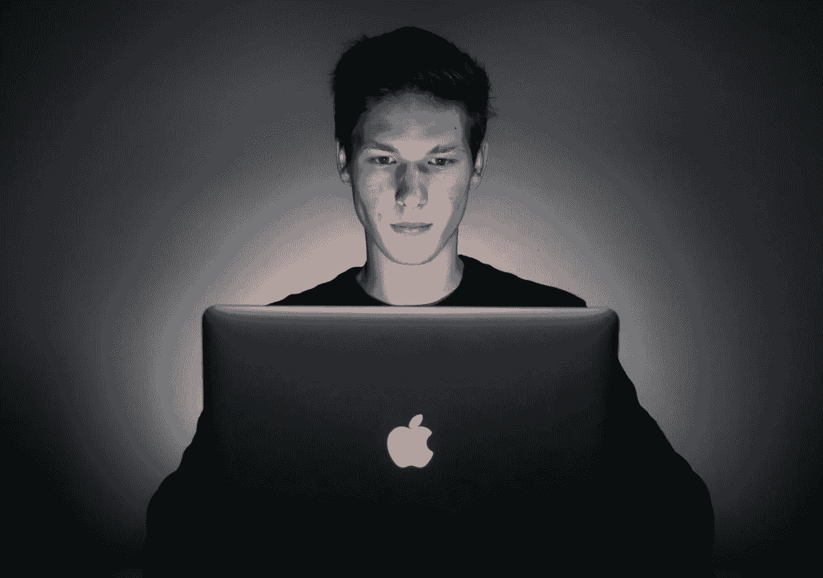 Image of white male looking at the screen of a Apple laptop computer. Image of white male looking at the screen of a Apple laptop computer.