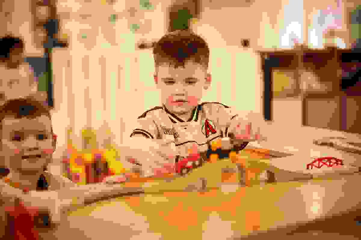 Child exploring with a wooden train set Child exploring with a wooden train set