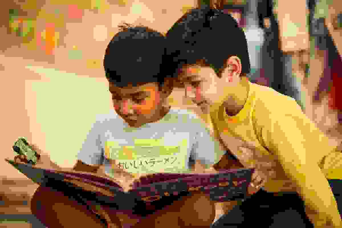 Two children reading a book together Two children reading a book together