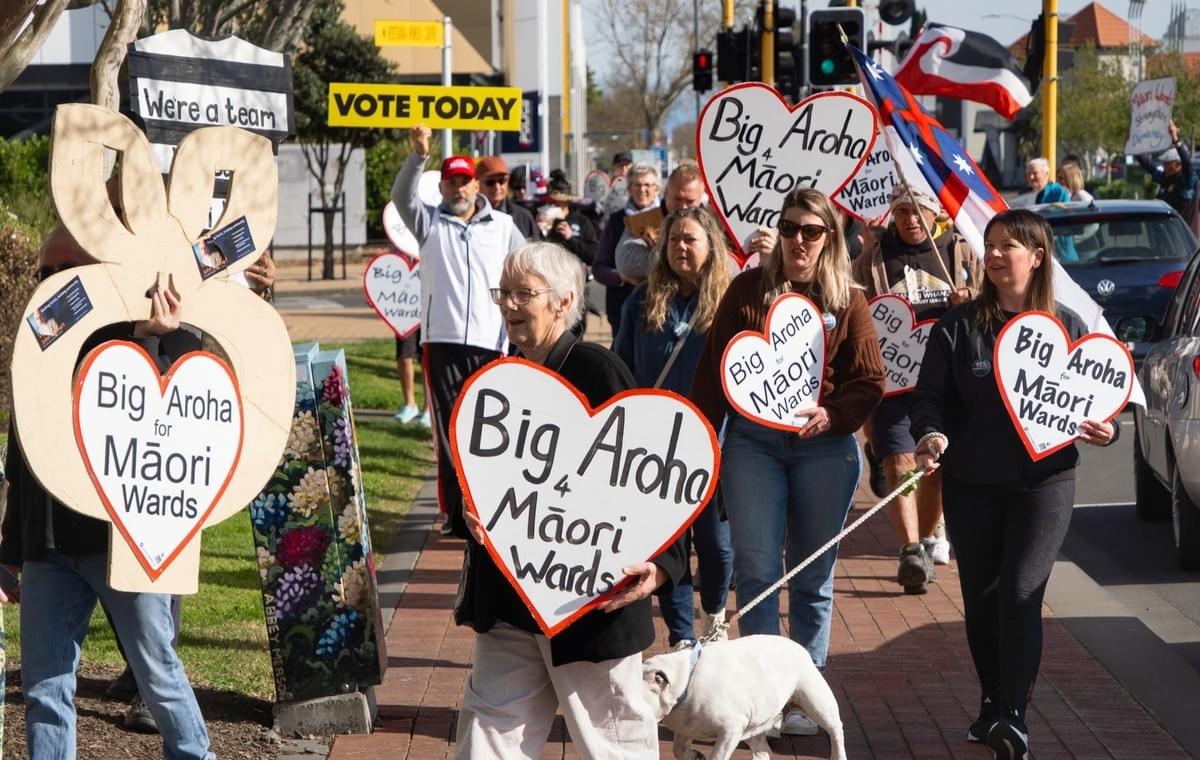 A collage from For Wards Hawkes Bay of pro-Māori ward supporters with their signs and love-hearts. Their rōpu distributed over 4000 Big Aroha for Māori Wards placards!