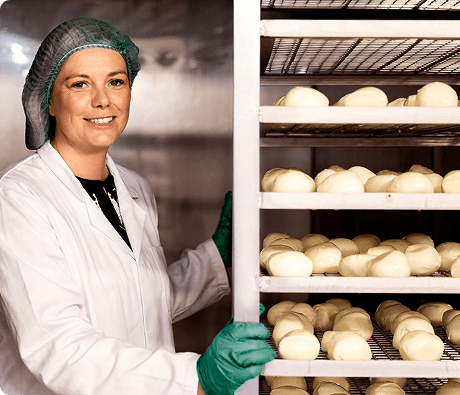 Lonergan family member beside racks of mozzarella during the smoking process.