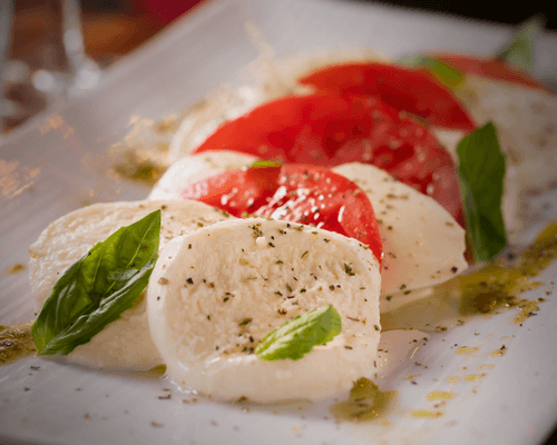 Fresh mozzarella slices layered with tomatoes and basil.