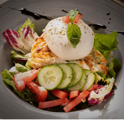 Fior di Latte mozzarella served on a fresh salad with tomatoes, cucumber and basil.