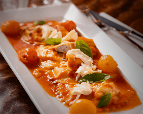Fresh mozzarella served with tomatoes, basil and pasta in a restaurant dish.