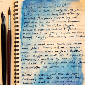 Picture of a blue journal page with lots of writing on it.The background is blue watercolour.