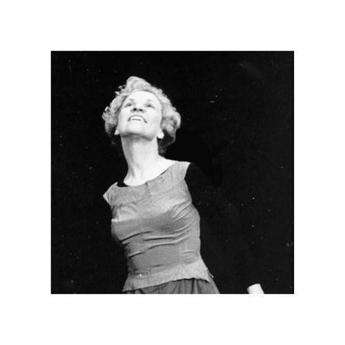 La photo est en noir et blanc. Une femme regarde vers le ciel. Ses deux bras, le long de son corps sont légèrement écartés. 