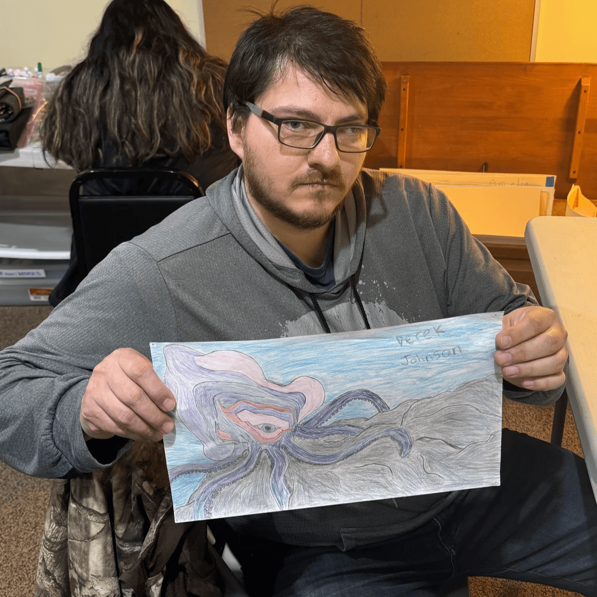 Artist Derek Johnson displaying art.
