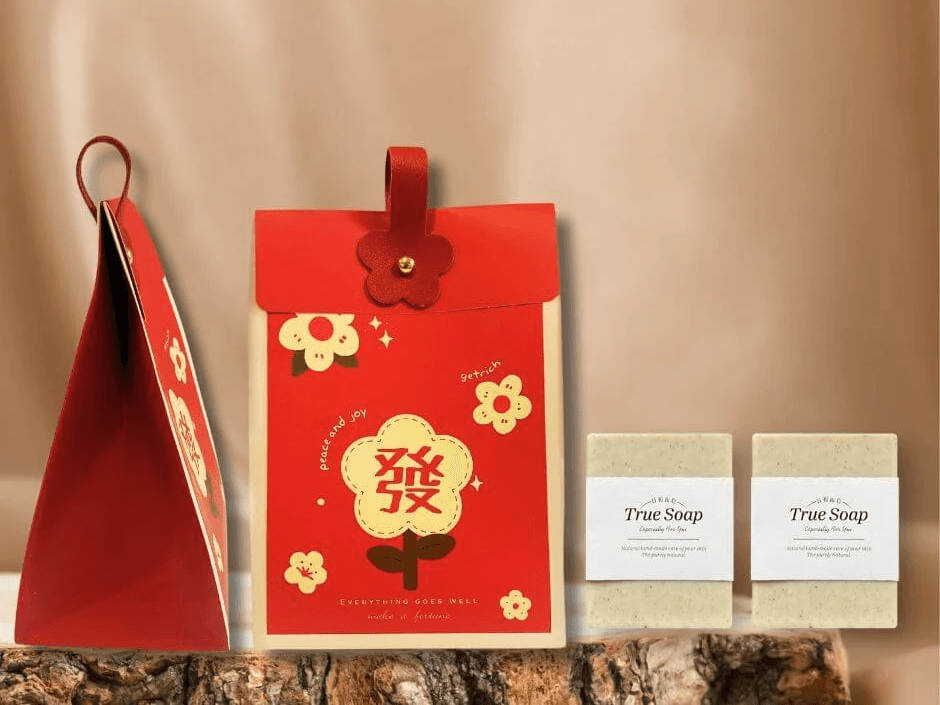 日初而皂農曆新年限定禮盒，紅色手提袋印有可愛「發」字與花朵圖案，搭配兩入天然手工皂