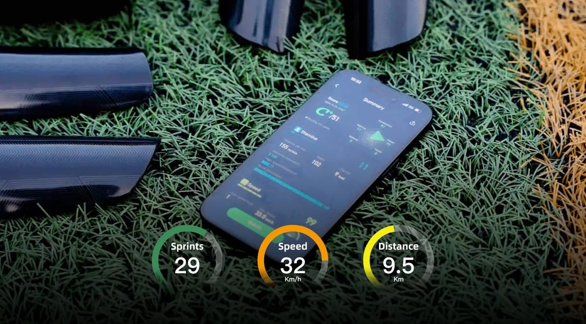 INSAIT JOY smart shin guards on a pitch with a smartphone displaying the data report, highlighting key metrics: Sprints, Speed, and Distance Covered.