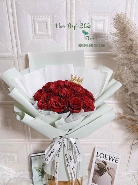 Bó hoa sáp Glitter Roses - HST27 được bó với 15 hoa hồng đỏ kim tuyến trang trí kèm vương miện, tượng trưng cho sự tôn vinh phụ nữ trong ngày 8/3