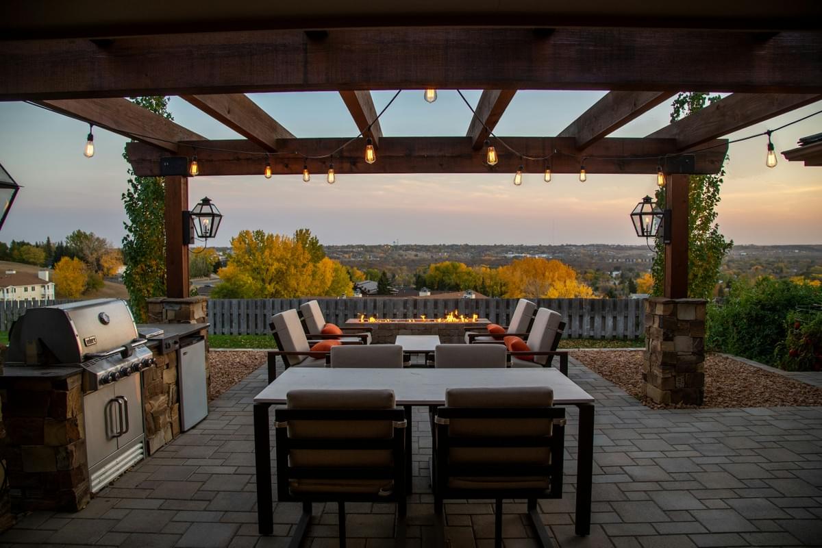 Paver patio with pergola, outdoor kitchen,  fire pit and seating. Custom patio builder Midland