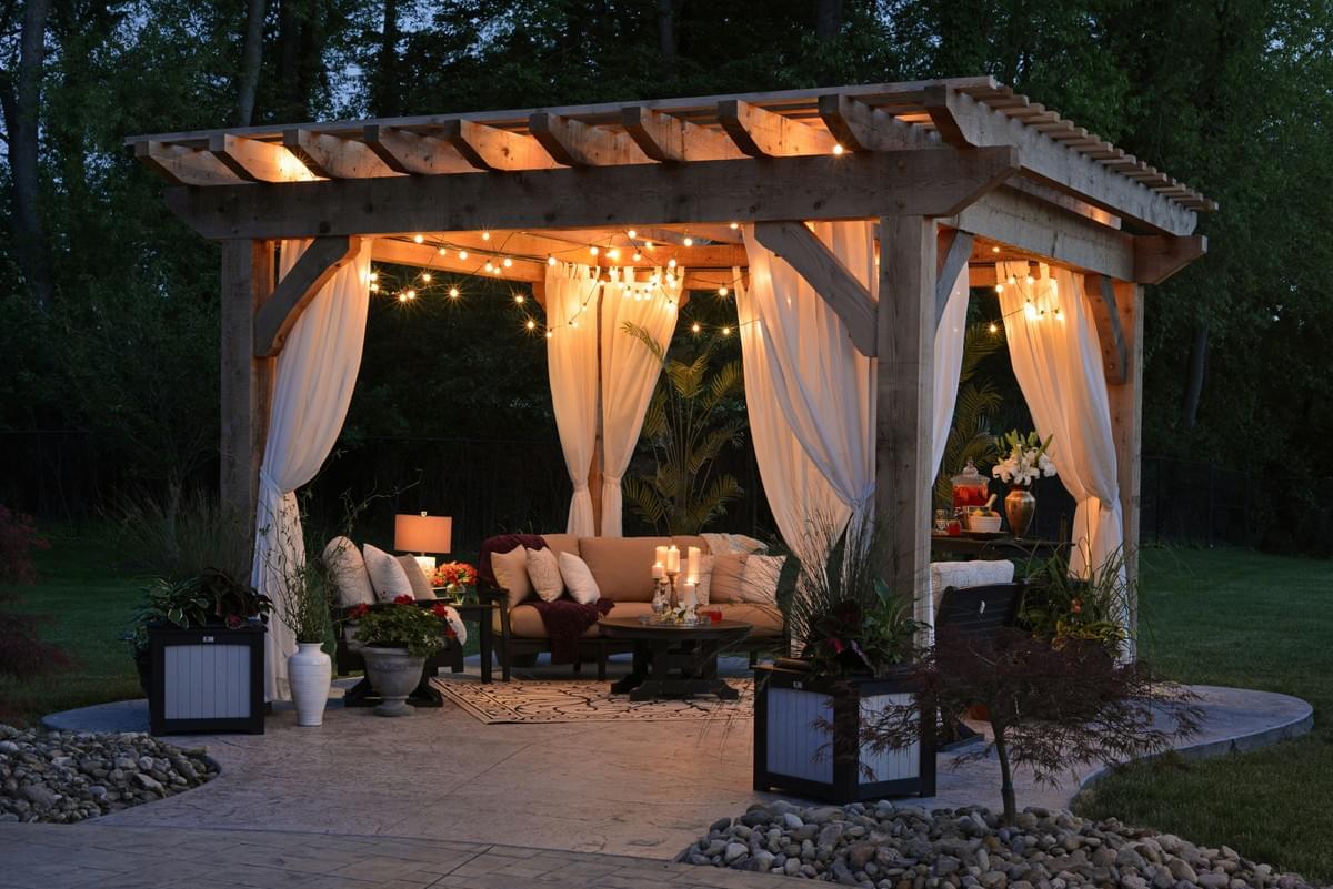 Traditional Cedar Pergola with Lights and Drapes in Midland TX. Custom pergola builder Midland