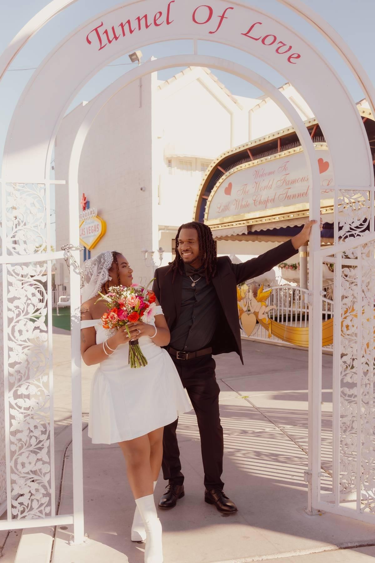 Newlyweds posing outside the iconic Little White Wedding Chapel in Las Vegas after their ceremony, captured by Falling Rocks Photography.