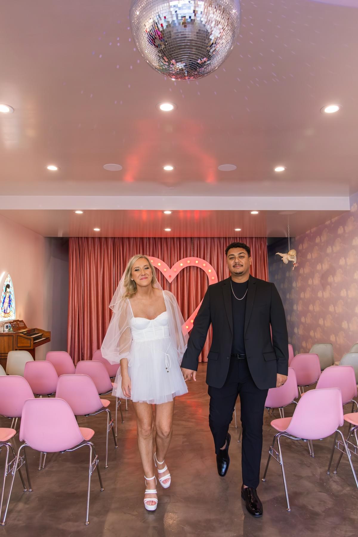Newlywed couple walking down the aisle at Sure Thing Chapel in Las Vegas, celebrating their intimate elopement.