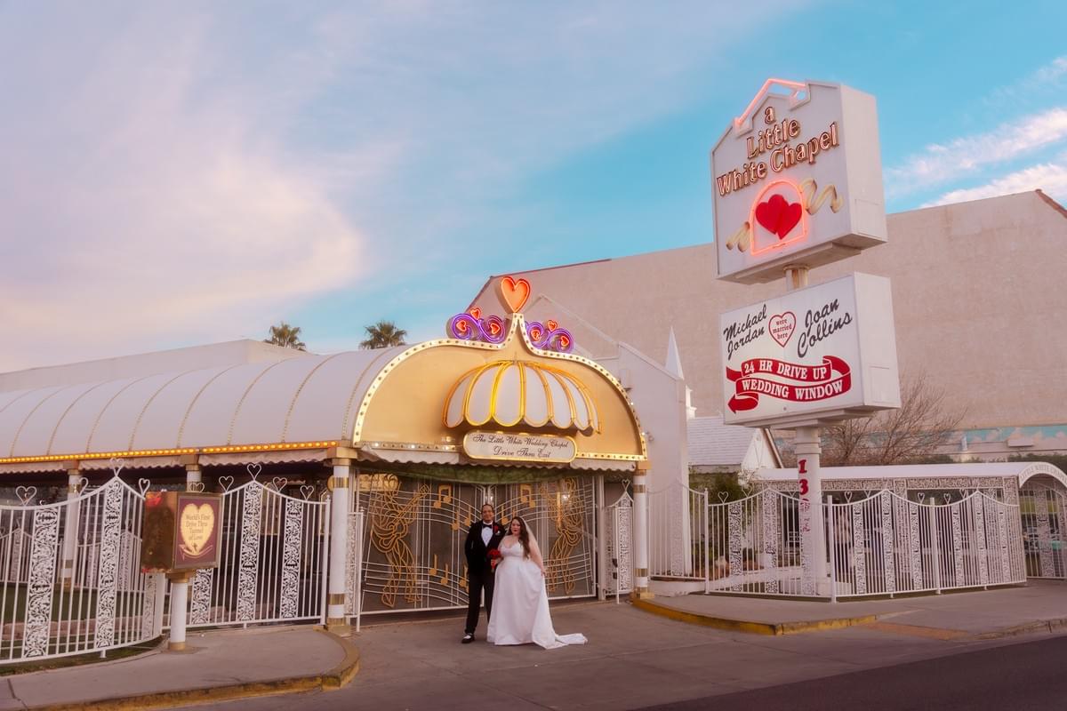 Romantic sunset portrait of a couple in elopement attire outside the world-famous Little White Wedding Chapel in Las Vegas.