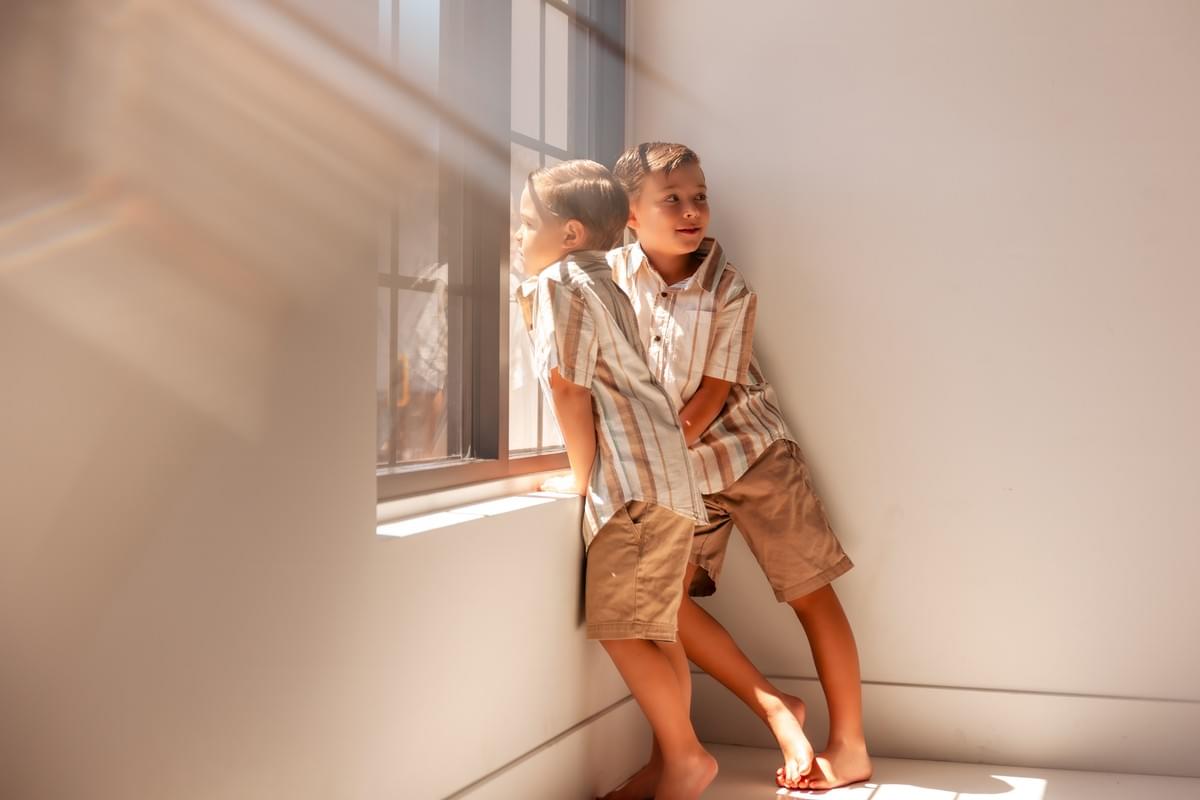 Two young boys smiling during a family studio photography session at The White Space LV in Las Vegas, captured by Falling Rocks Photography.