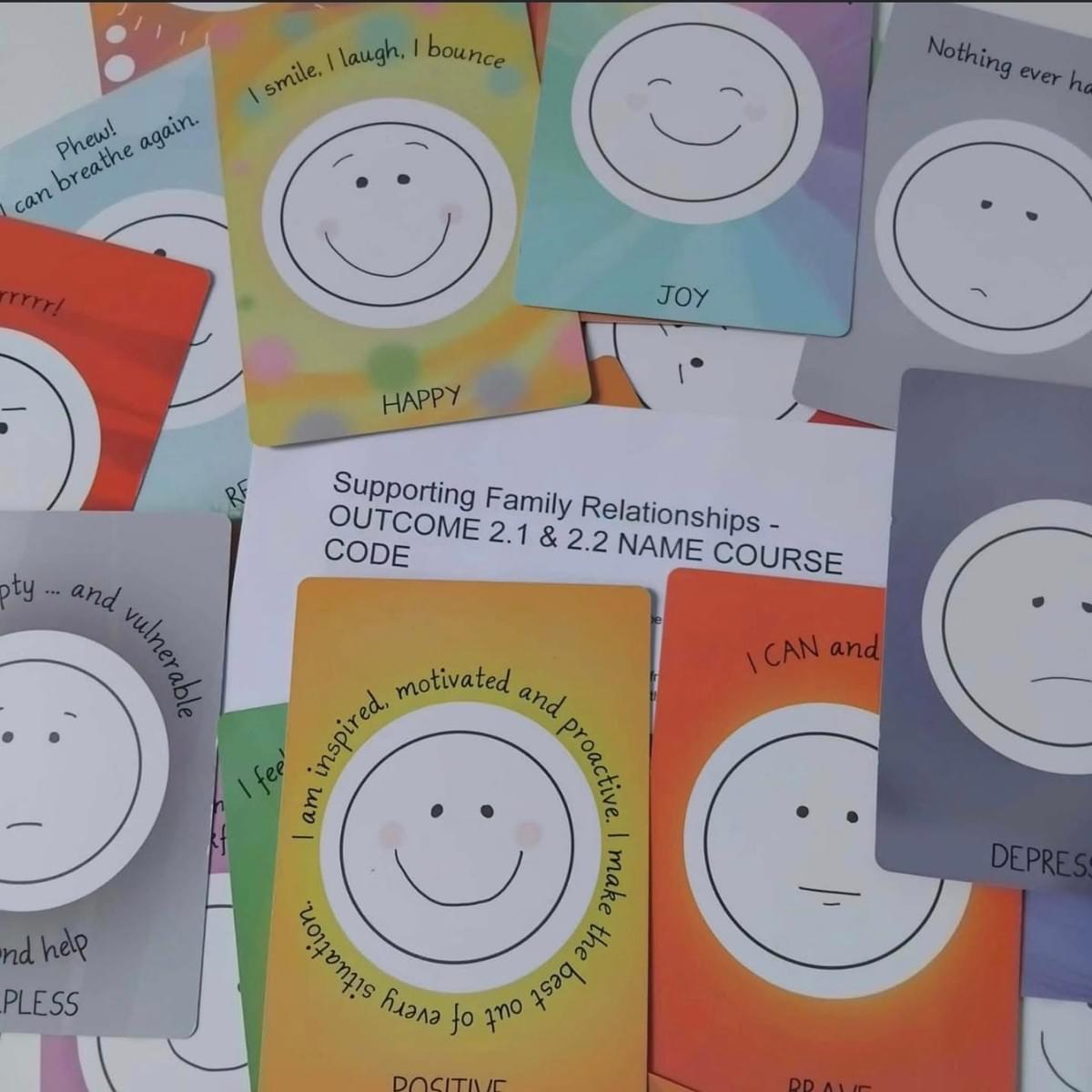 Colourful emotion cards with simple face drawings showing feelings like happy, joy, positive, and depressed, displayed around a ‘Supporting Family Relationships’ course sheet.