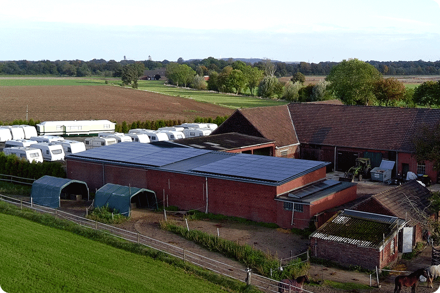 System fotowoltaiczny TOPCon zainstalowany na dachu wiejskiego budynku komercyjnego lub przemysłowego; odpowiedni dla magazynów, gospodarstw i standardowych projektów dachowych, pokazujący zalety tej technologii pod względem sprawności, stabilności i łatwości wdrożenia przy kontrolowanym budżecie.