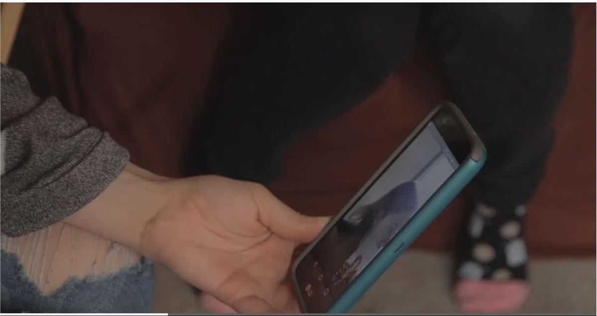 Participant is on a video call with a researcher from Anthro-Tech. The participant is using one hand to hold the phone, and one hand to sign ASL.