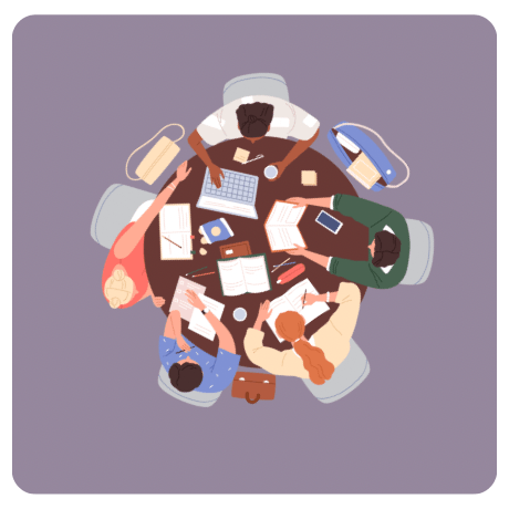 Men and woman  sitting at a round table writing news letters and working on laptops writing news articles 