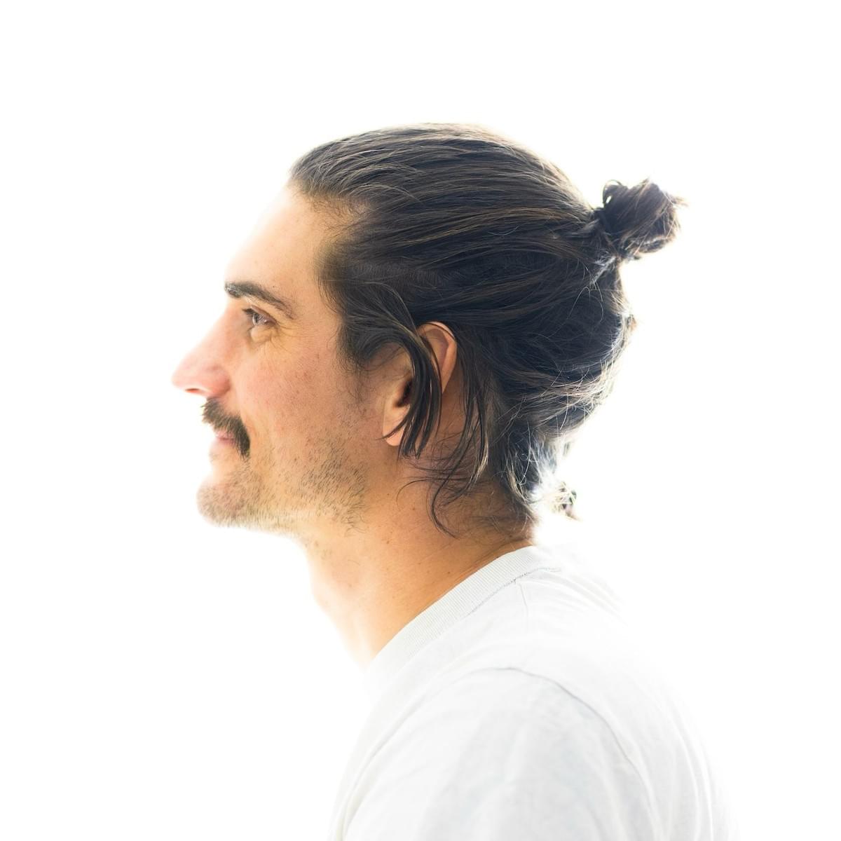 A man’s thoughtful expression, representing the overactive mind in stress — and the importance of addressing mental patterns in healing.