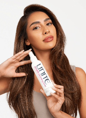 Person with long, smooth hair holding Unite Boosta Volumizing Spray beside the face, showcasing the volumizing hair styling product. Person with long, smooth hair holding Unite Boosta Volumizing Spray beside the face, showcasing the volumizing hair styling product.