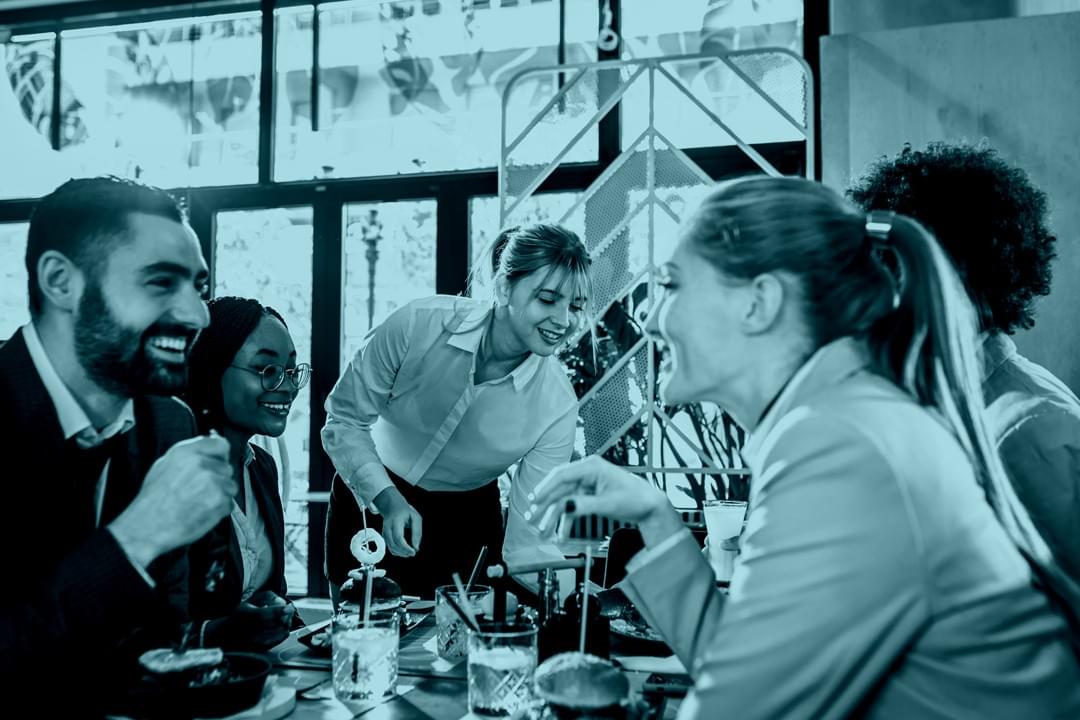 Restaurant staff preparing food and greeting customers, showcasing hospitality business services