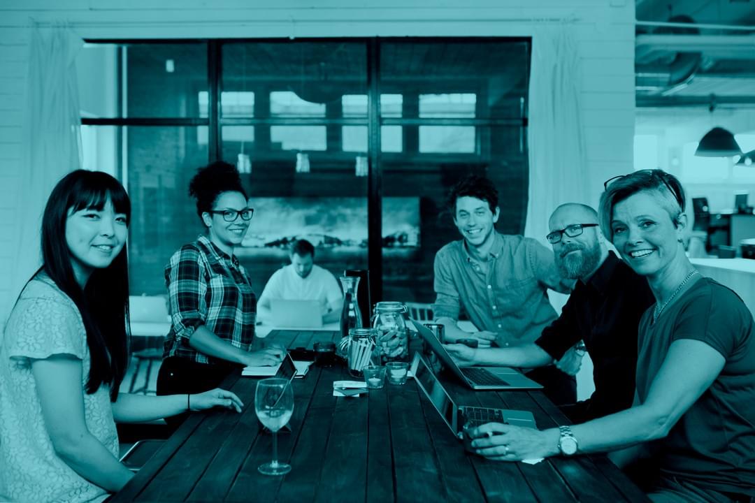 Startup team collaborating at laptops in a modern office, representing tech and SaaS companies