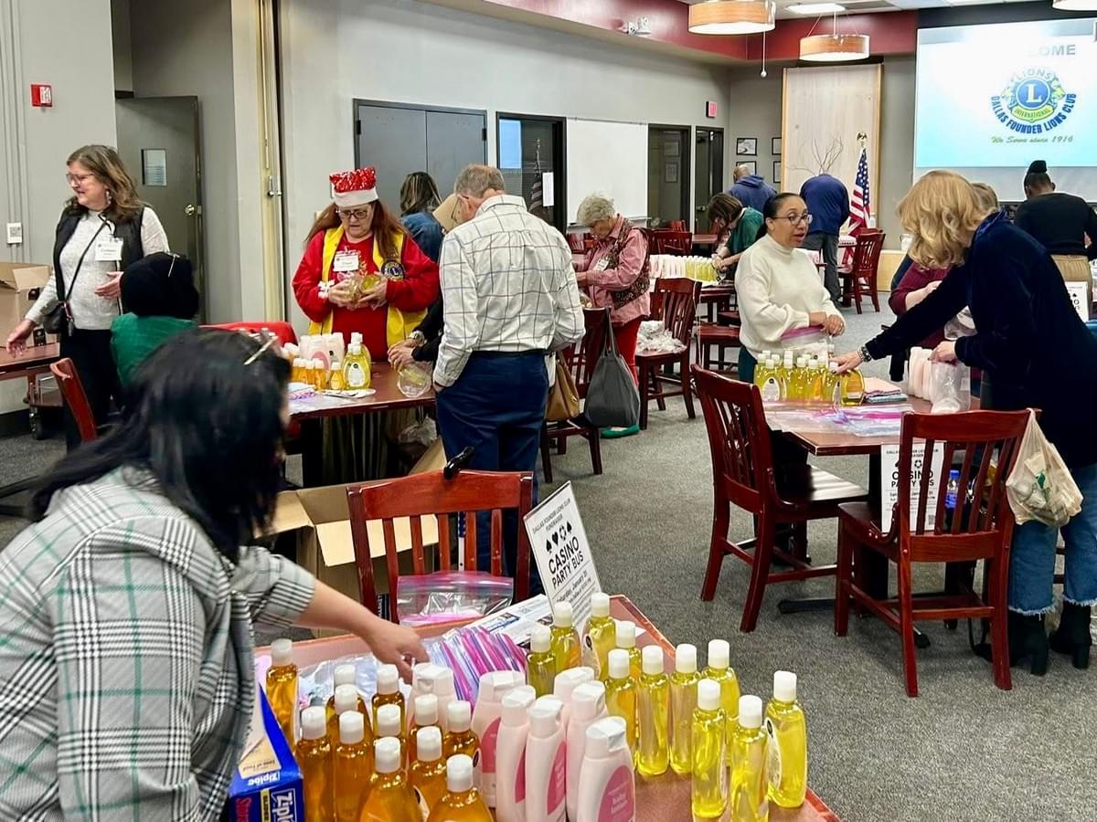 Picture of Dallas Founder Lions Club working on baby hygeine kits service project. 